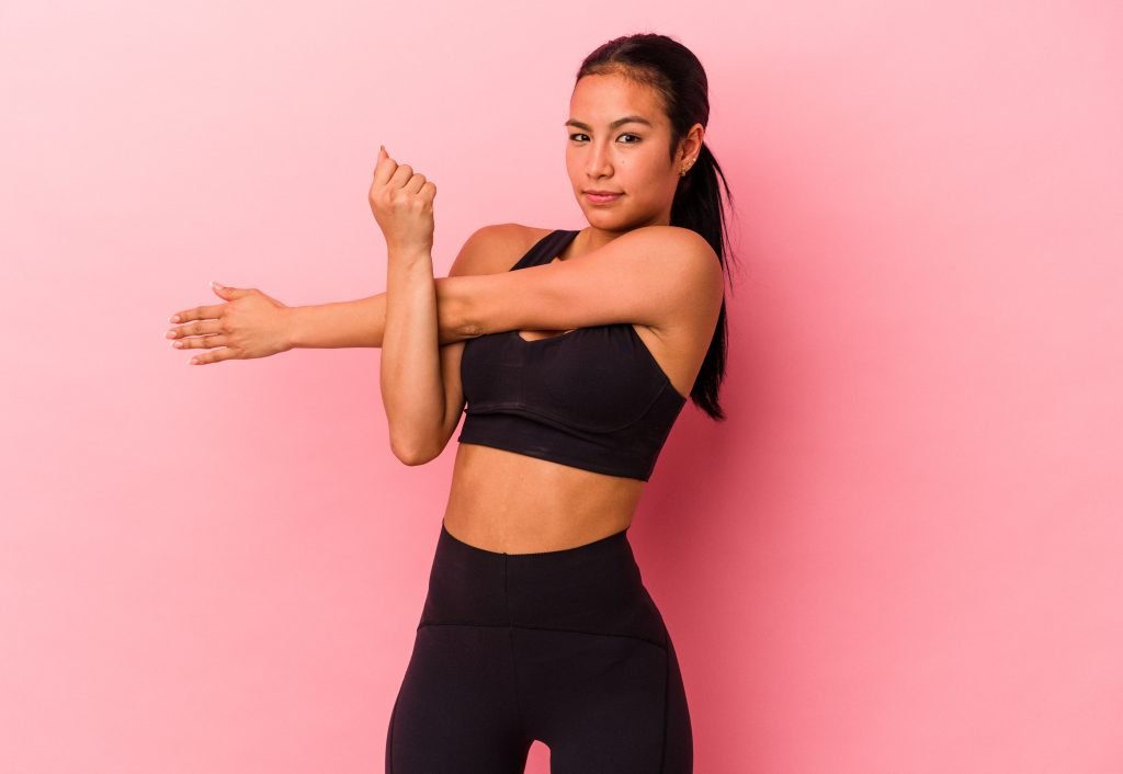 young female trainer stretching in yoga clothes at fit trainers